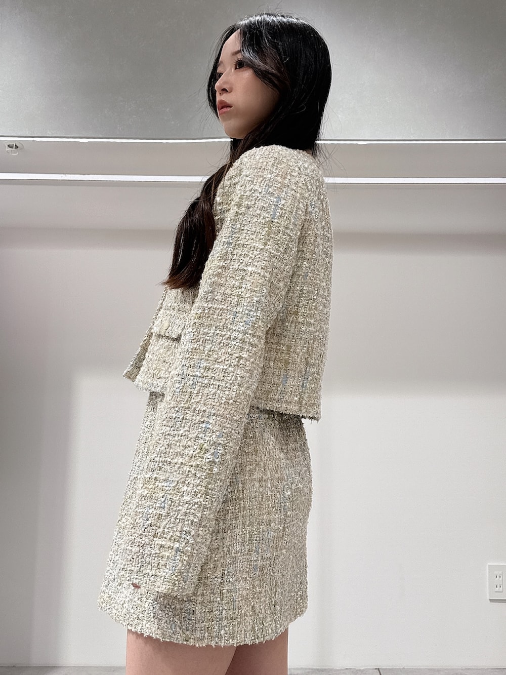 グリーン系のテーラードジャケット、グリーン系のスカート、ブラウン系のブーツを着用したレディースの春コーディネートの5枚目の写真