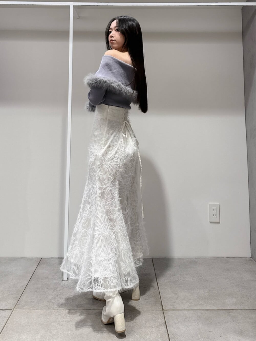 ホワイト系のスカート、ホワイト系のブーツ、グレー系のニット/セーターを着用したレディースの冬コーディネートの3枚目の写真