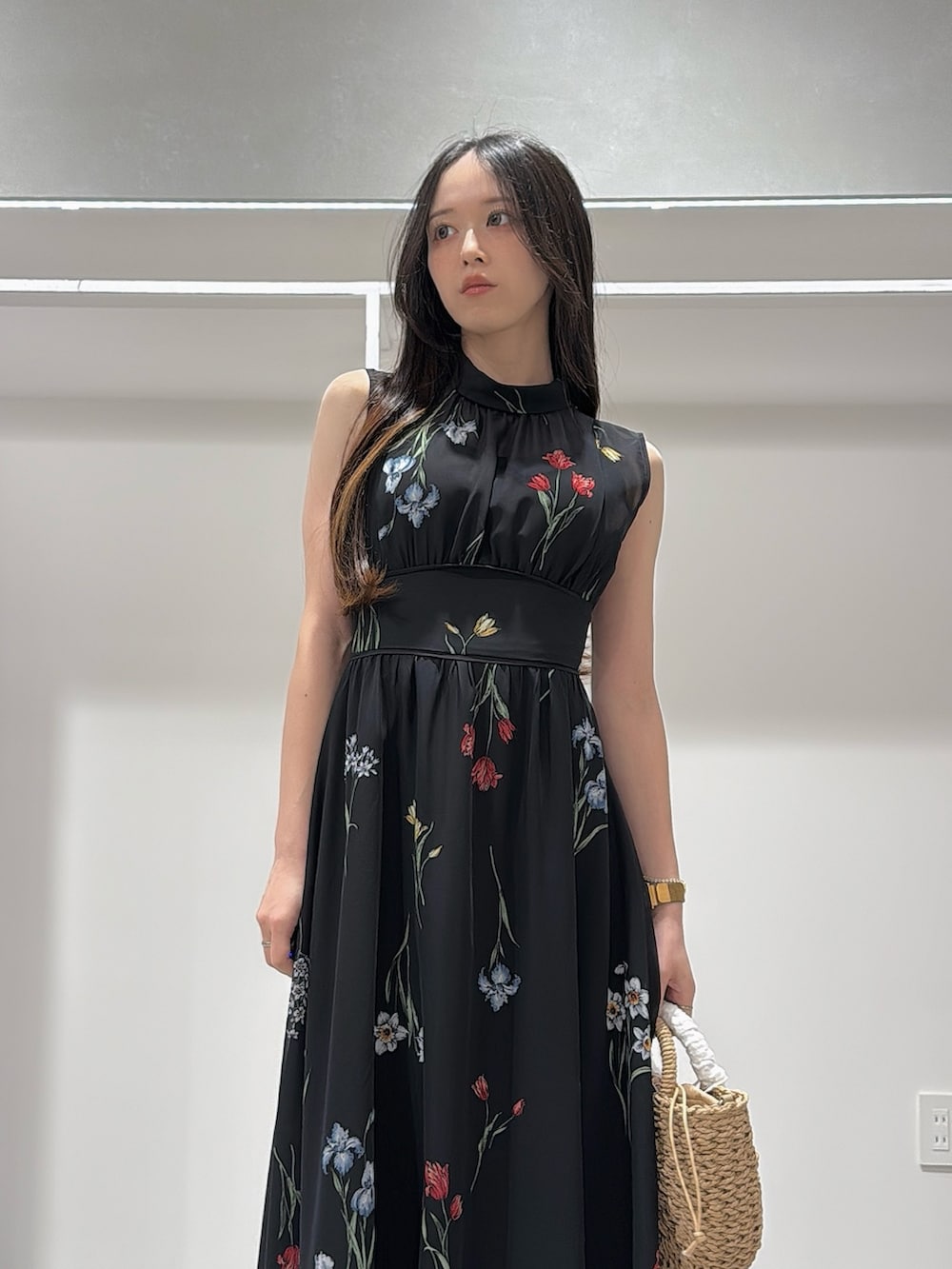ベージュ系のハンドバッグ、ブラック系のワンピース、ブラック系のサンダルを着用したレディースの夏コーディネートの4枚目の写真