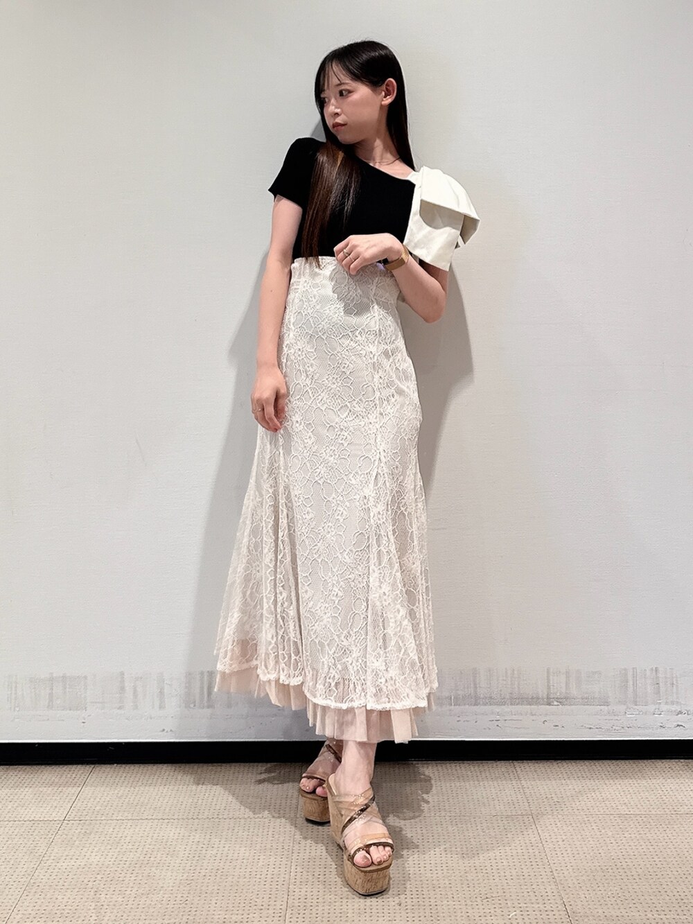 ブラック系のニット/セーター、ホワイト系のスカート、ブラウン系のサンダルを着用したレディースの夏コーディネートの2枚目の写真