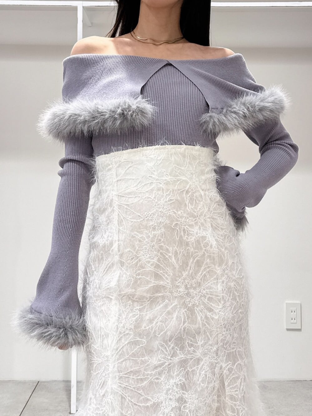 ホワイト系のスカート、ホワイト系のブーツ、グレー系のニット/セーターを着用したレディースの冬コーディネートの5枚目の写真