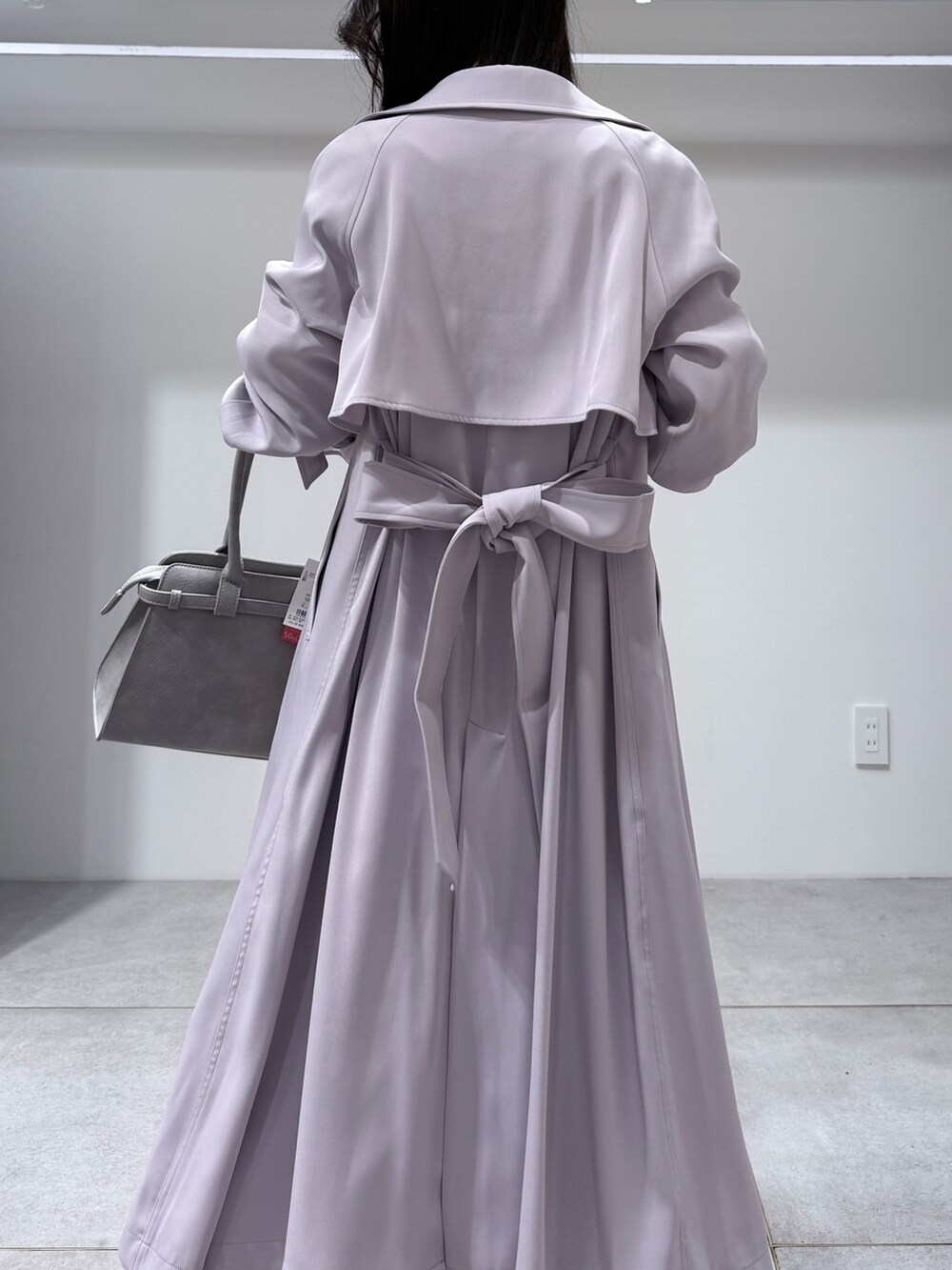 パープル系のトレンチコート、ホワイト系のワンピース、グレー系のハンドバッグを着用したレディースの冬コーディネートの8枚目の写真