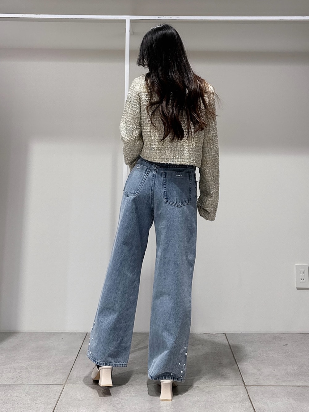 グリーン系のテーラードジャケット、ホワイト系のニット/セーター、ブルー系のデニムパンツを着用したレディースの春コーディネートの3枚目の写真