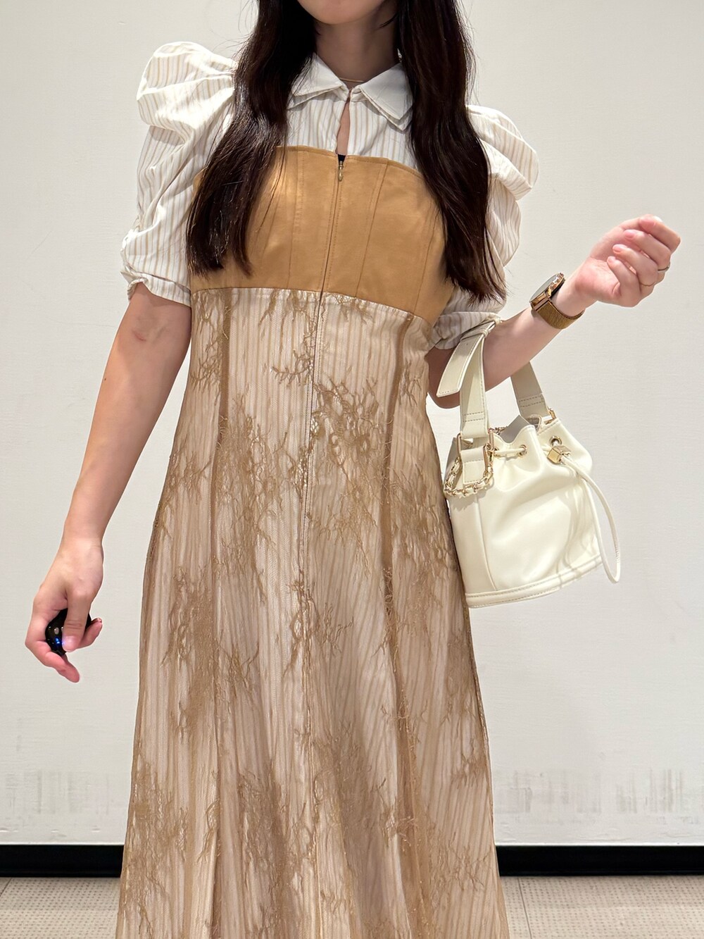 ベージュ系のワンピース、ホワイト系のハンドバッグ、ホワイト系のブーツを着用したレディースの夏コーディネートの4枚目の写真