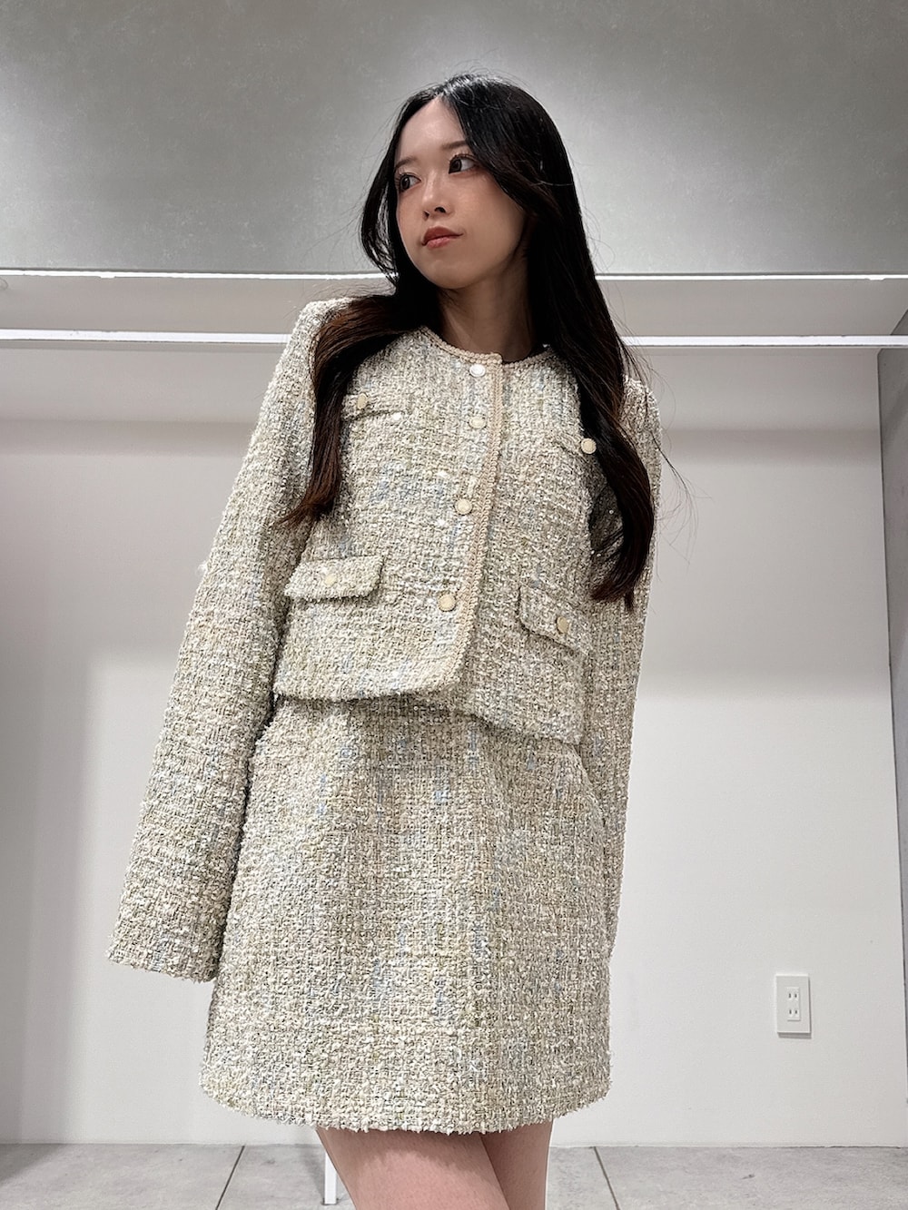 グリーン系のテーラードジャケット、グリーン系のスカート、ブラウン系のブーツを着用したレディースの春コーディネートの4枚目の写真