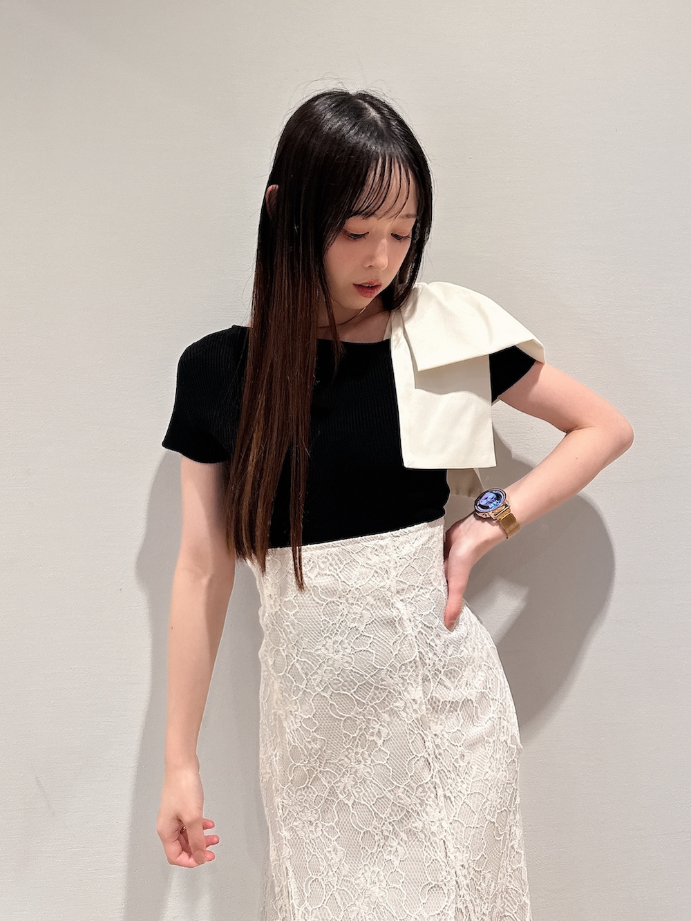 ブラック系のニット/セーター、ホワイト系のスカート、ブラウン系のサンダルを着用したレディースの夏コーディネートの7枚目の写真