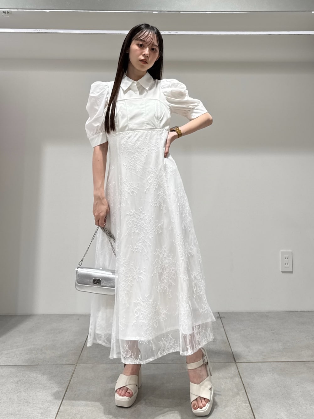 ホワイト系のワンピース、シルバー系のボディバッグ/ウエストポーチ、ホワイト系のサンダルを着用したレディースの夏コーディネートの2枚目の写真