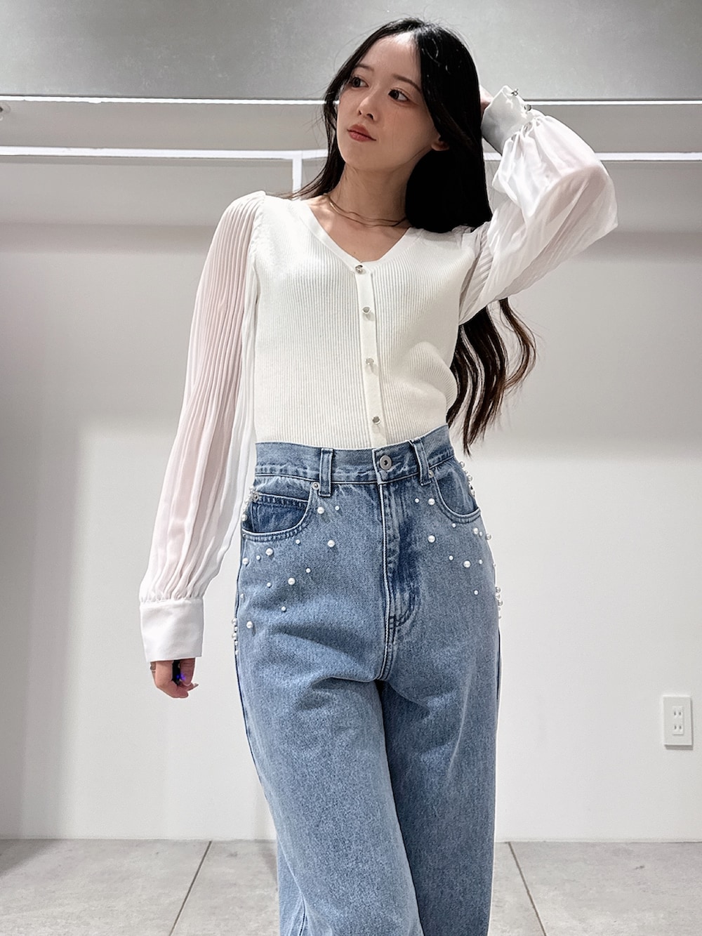 グリーン系のテーラードジャケット、ホワイト系のニット/セーター、ブルー系のデニムパンツを着用したレディースの春コーディネートの8枚目の写真