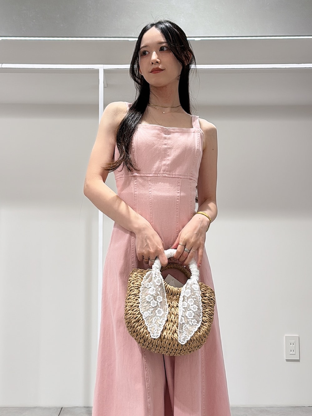 ピンク系のワンピース、ホワイト系のパンプス、ベージュ系のハンドバッグを着用したレディースの春コーディネートの4枚目の写真