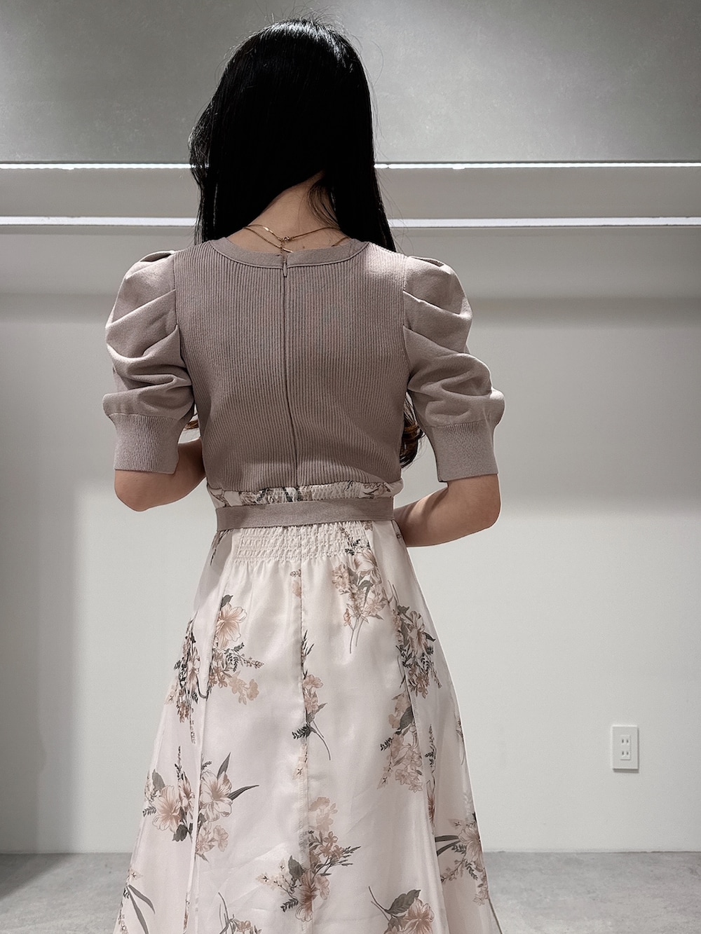 ベージュ系のワンピース、ブラウン系のハンドバッグ、ブラウン系のパンプスを着用したレディースの冬コーディネートの6枚目の写真