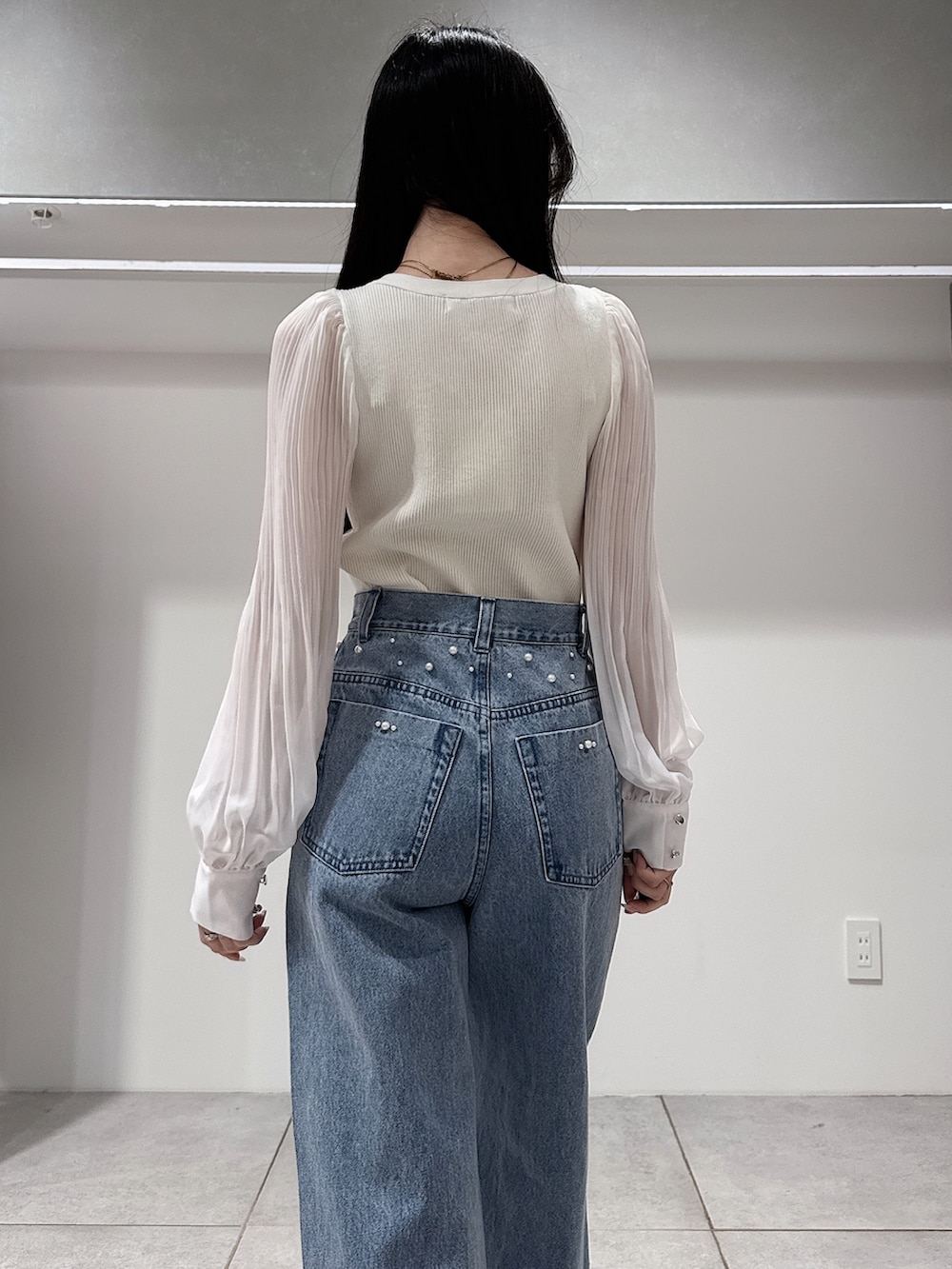 グリーン系のテーラードジャケット、ホワイト系のニット/セーター、ブルー系のデニムパンツを着用したレディースの春コーディネートの10枚目の写真