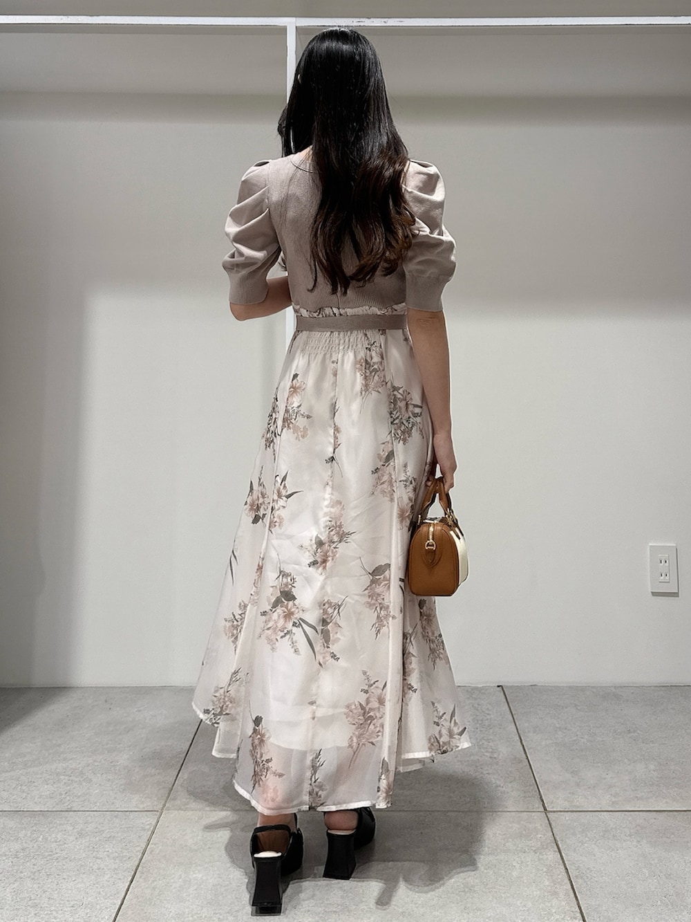 ベージュ系のワンピース、ブラウン系のハンドバッグ、ブラウン系のパンプスを着用したレディースの冬コーディネートの3枚目の写真