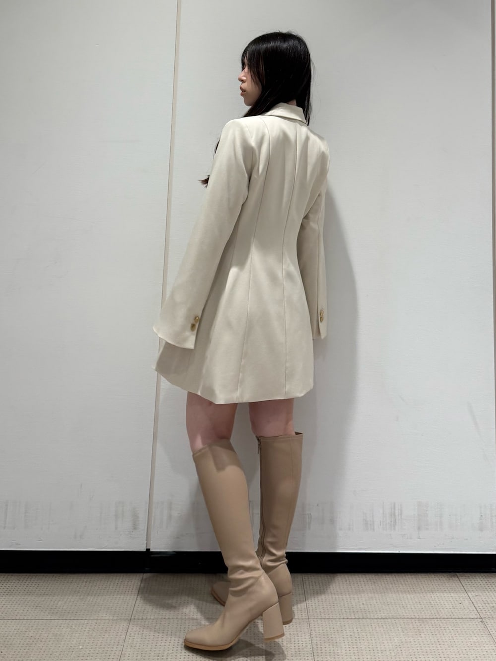 ホワイト系のワンピース、ベージュ系のブーツを着用したレディースの夏コーディネートの3枚目の写真