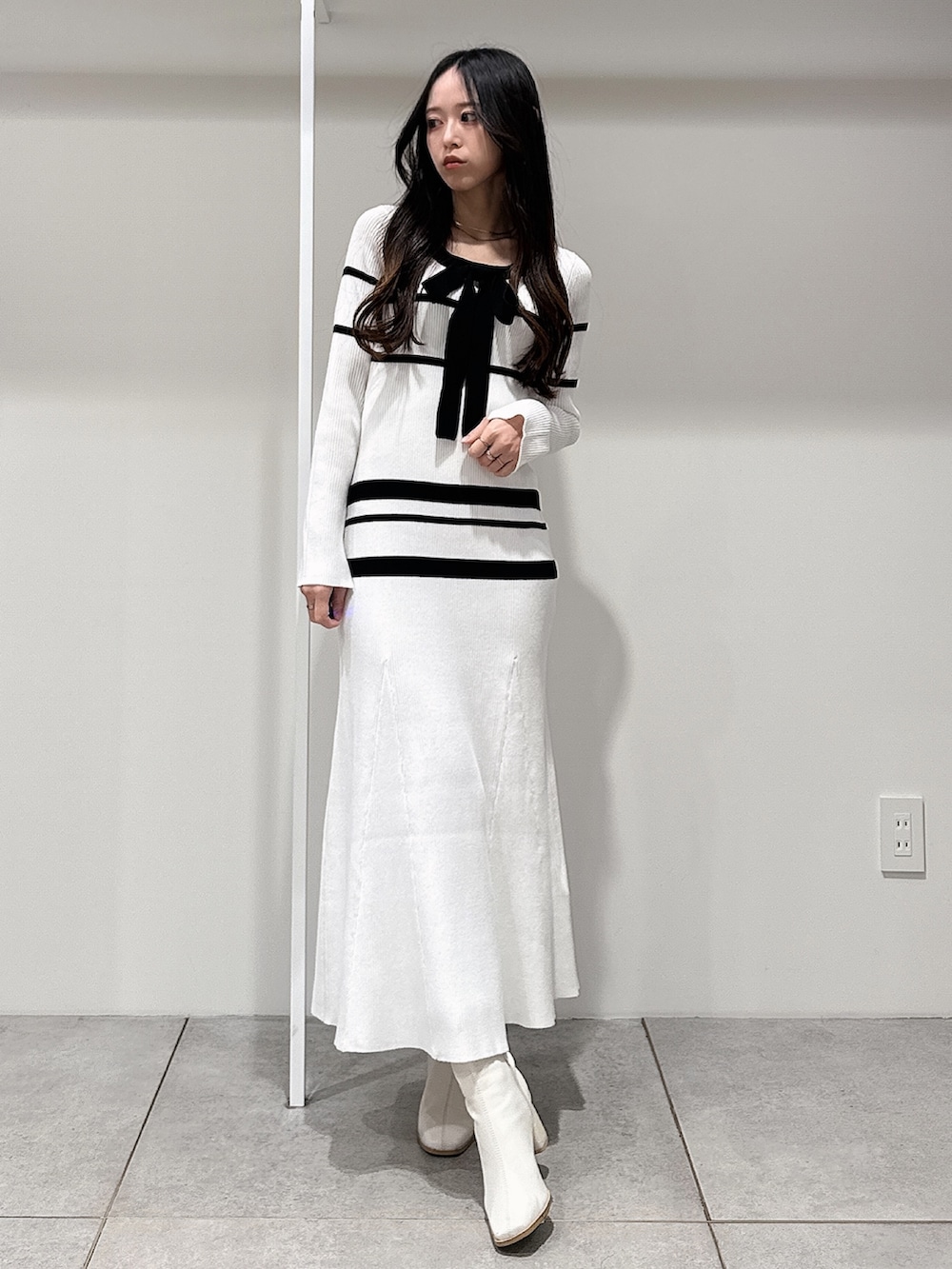 ブルー系のトレンチコート、ホワイト系のブーツ、ホワイト系のワンピースを着用したレディースの冬コーディネートの8枚目の写真