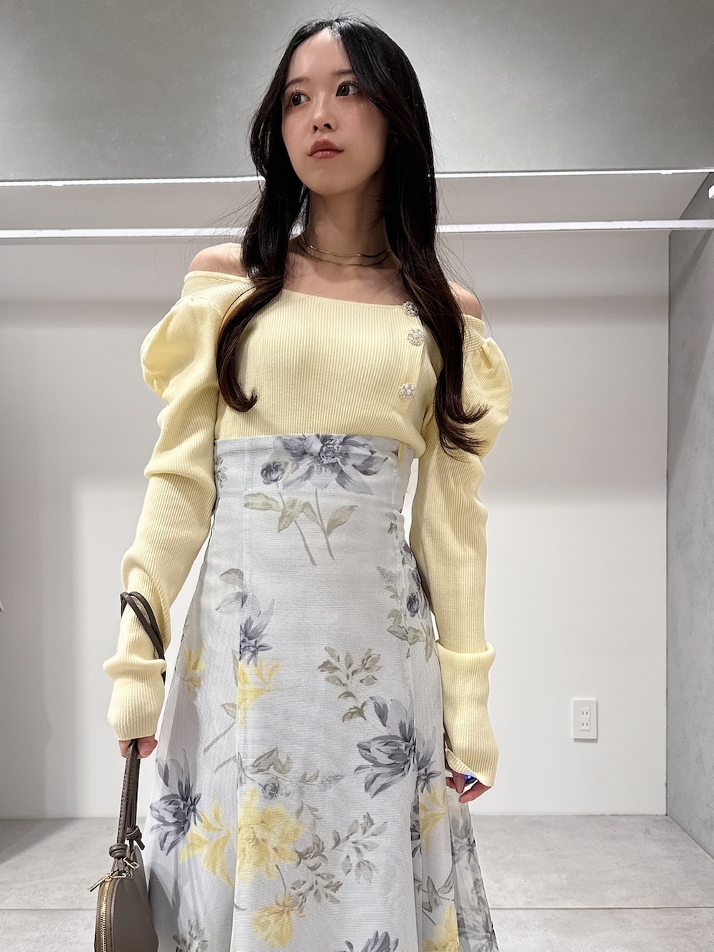 イエロー系のニット/セーター、グリーン系のスカート、ブラウン系のパンプスを着用したレディースの冬コーディネートの4枚目の写真