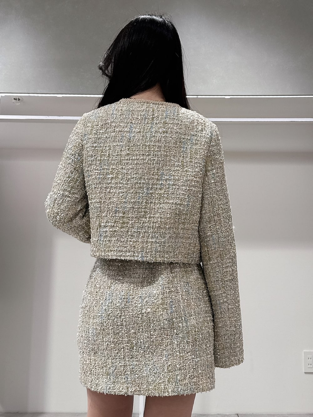 グリーン系のテーラードジャケット、グリーン系のスカート、ブラウン系のブーツを着用したレディースの春コーディネートの6枚目の写真