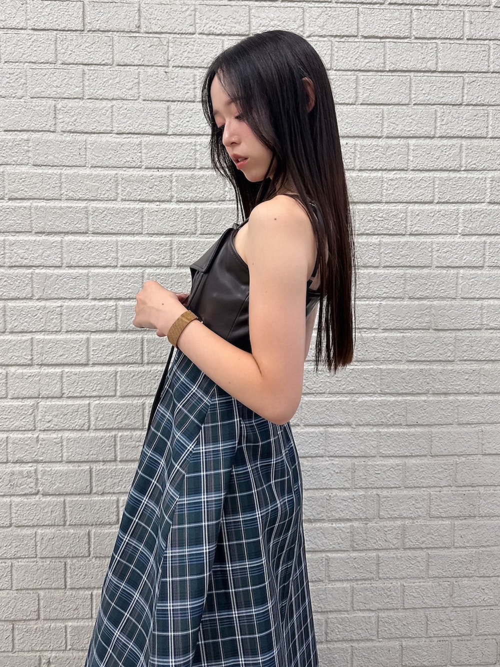 グリーン系のワンピース、ブラウン系のブーツを着用したレディースの秋コーディネートの6枚目の写真