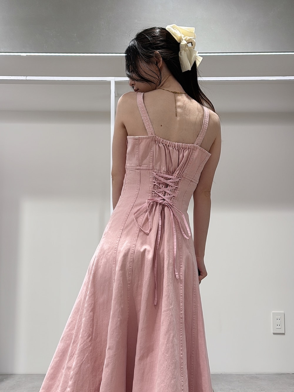 ピンク系のワンピース、ホワイト系のパンプス、ベージュ系のハンドバッグを着用したレディースの春コーディネートの6枚目の写真