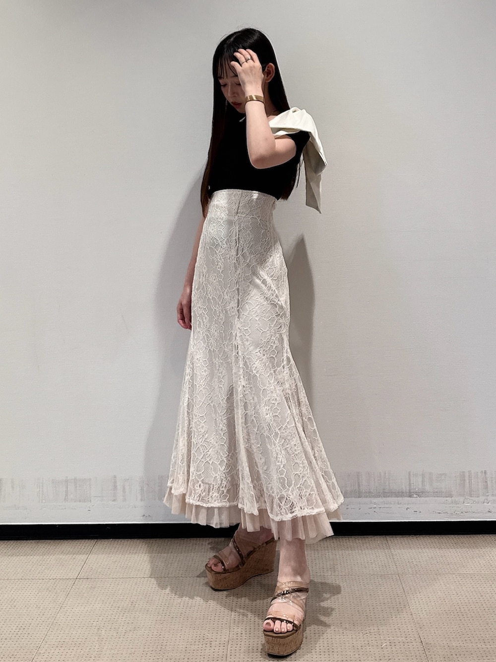 ブラック系のニット/セーター、ホワイト系のスカート、ブラウン系のサンダルを着用したレディースの夏コーディネートの5枚目の写真