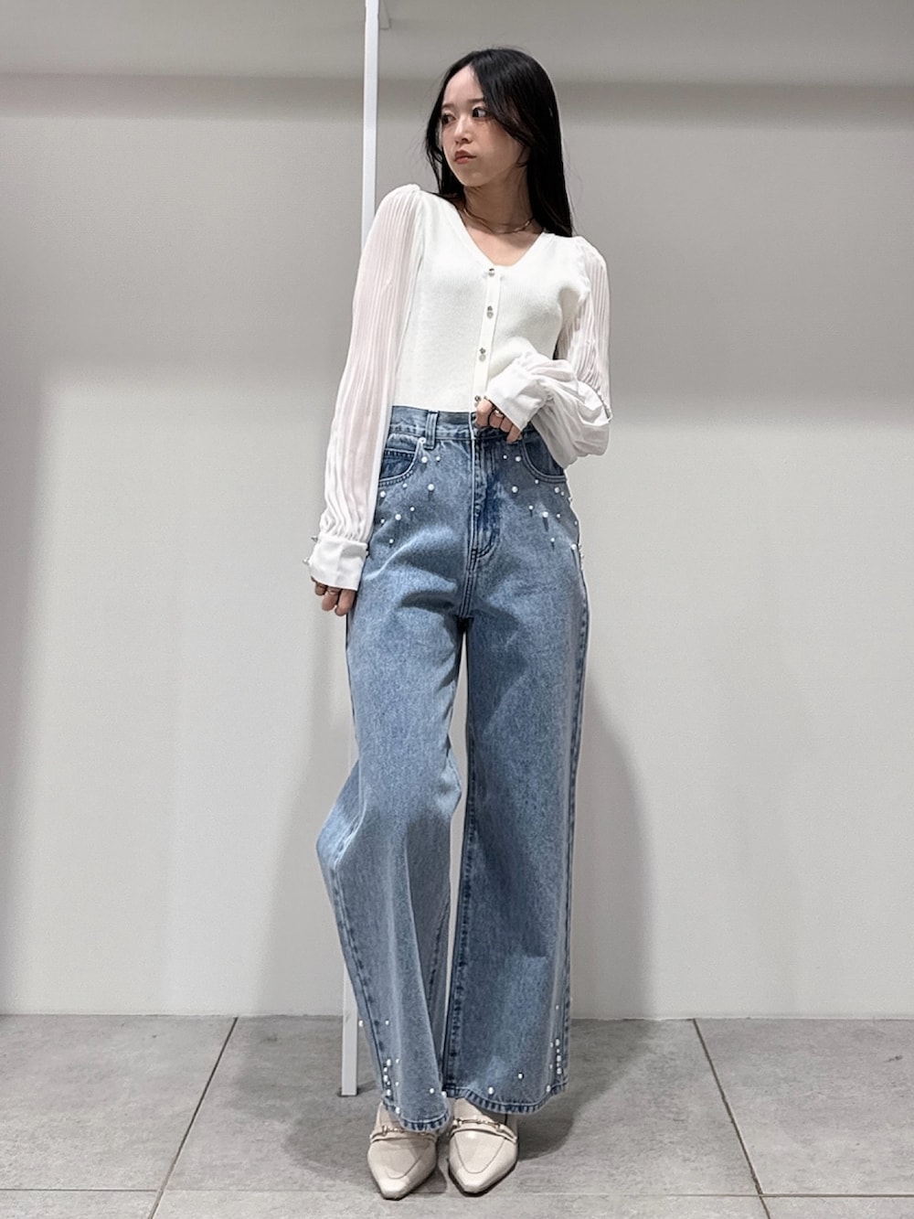 グリーン系のテーラードジャケット、ホワイト系のニット/セーター、ブルー系のデニムパンツを着用したレディースの春コーディネートの7枚目の写真