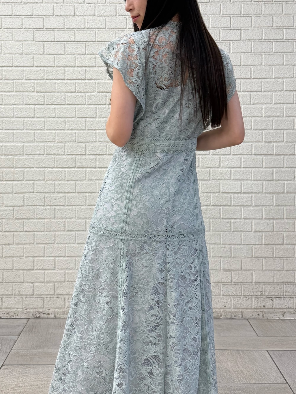 グリーン系のドレス、ホワイト系のパンプスを着用したレディースの秋コーディネートの7枚目の写真