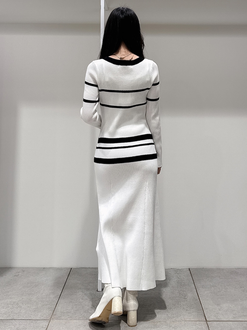 ブルー系のトレンチコート、ホワイト系のブーツ、ホワイト系のワンピースを着用したレディースの冬コーディネートの10枚目の写真