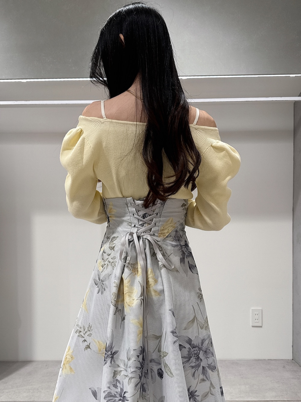 イエロー系のニット/セーター、グリーン系のスカート、ブラウン系のパンプスを着用したレディースの冬コーディネートの6枚目の写真