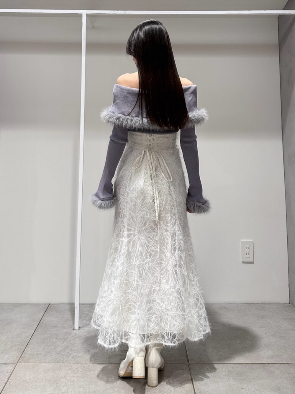 ホワイト系のスカート、ホワイト系のブーツ、グレー系のニット/セーターを着用したレディースの冬コーディネートの4枚目の写真