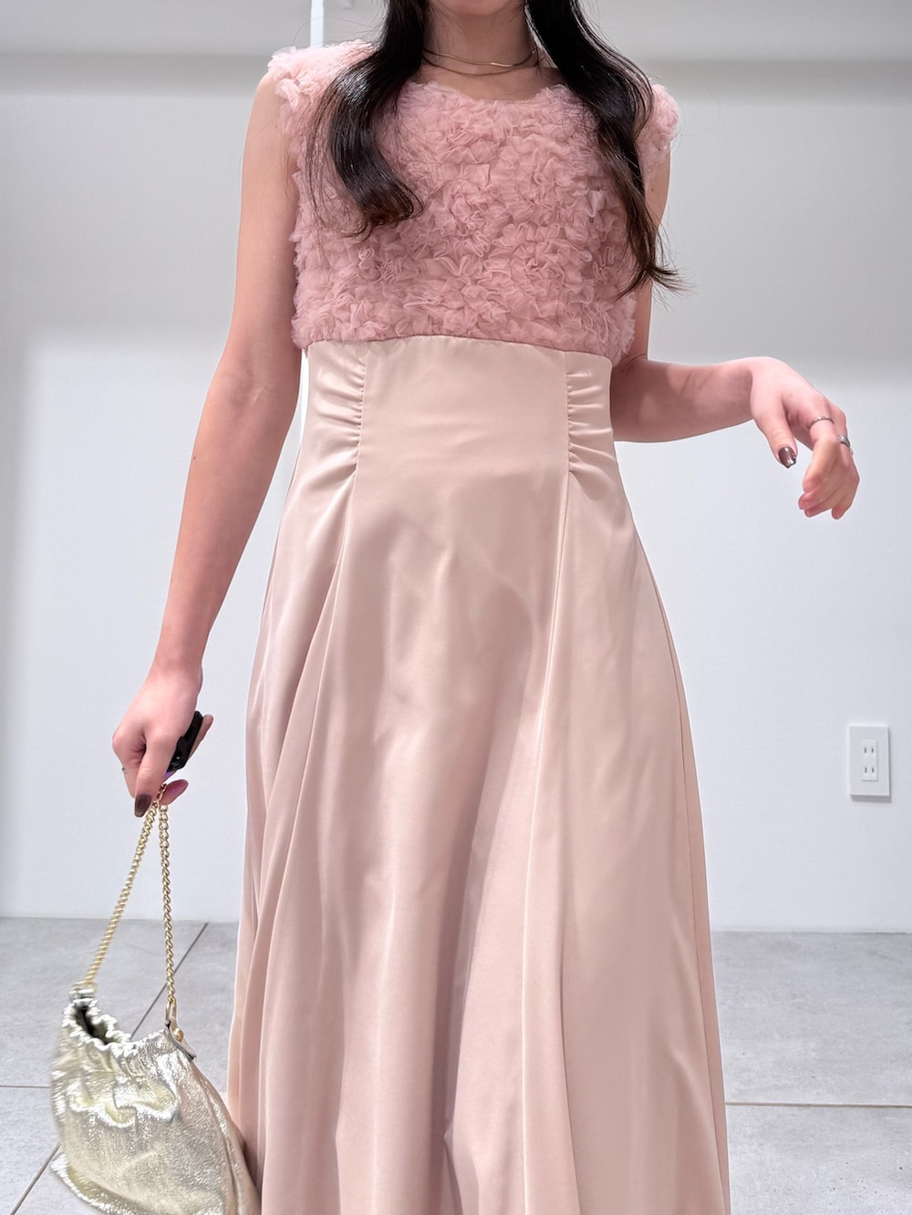 ホワイト系のトレンチコート、ピンク系のドレス、ゴールド系のショルダーバッグを着用したレディースの冬コーディネートの10枚目の写真