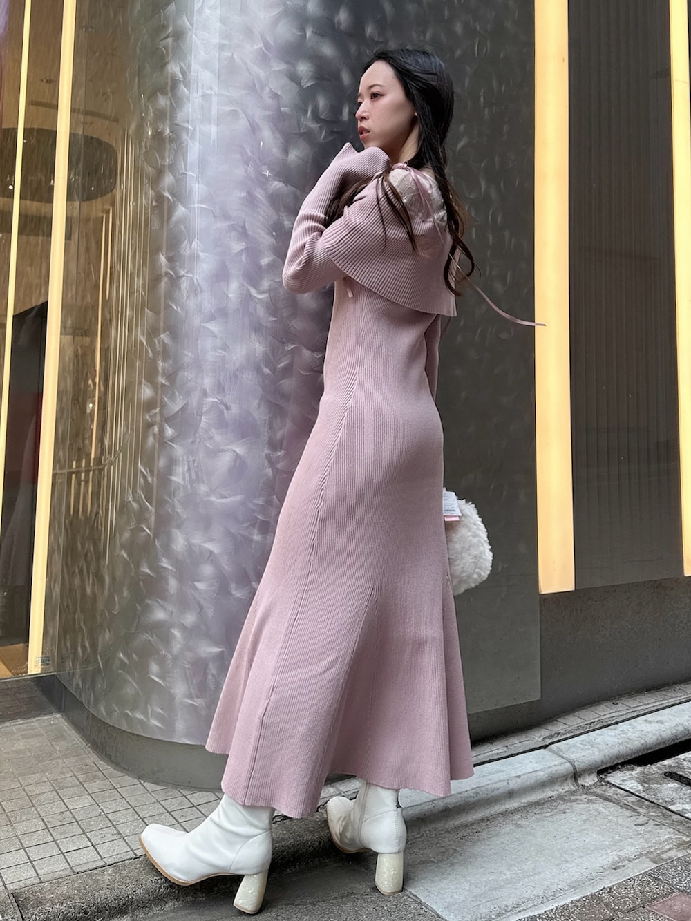 ピンク系のワンピース、ホワイト系のハンドバッグ、ホワイト系のブーツを着用したレディースの冬コーディネートの3枚目の写真