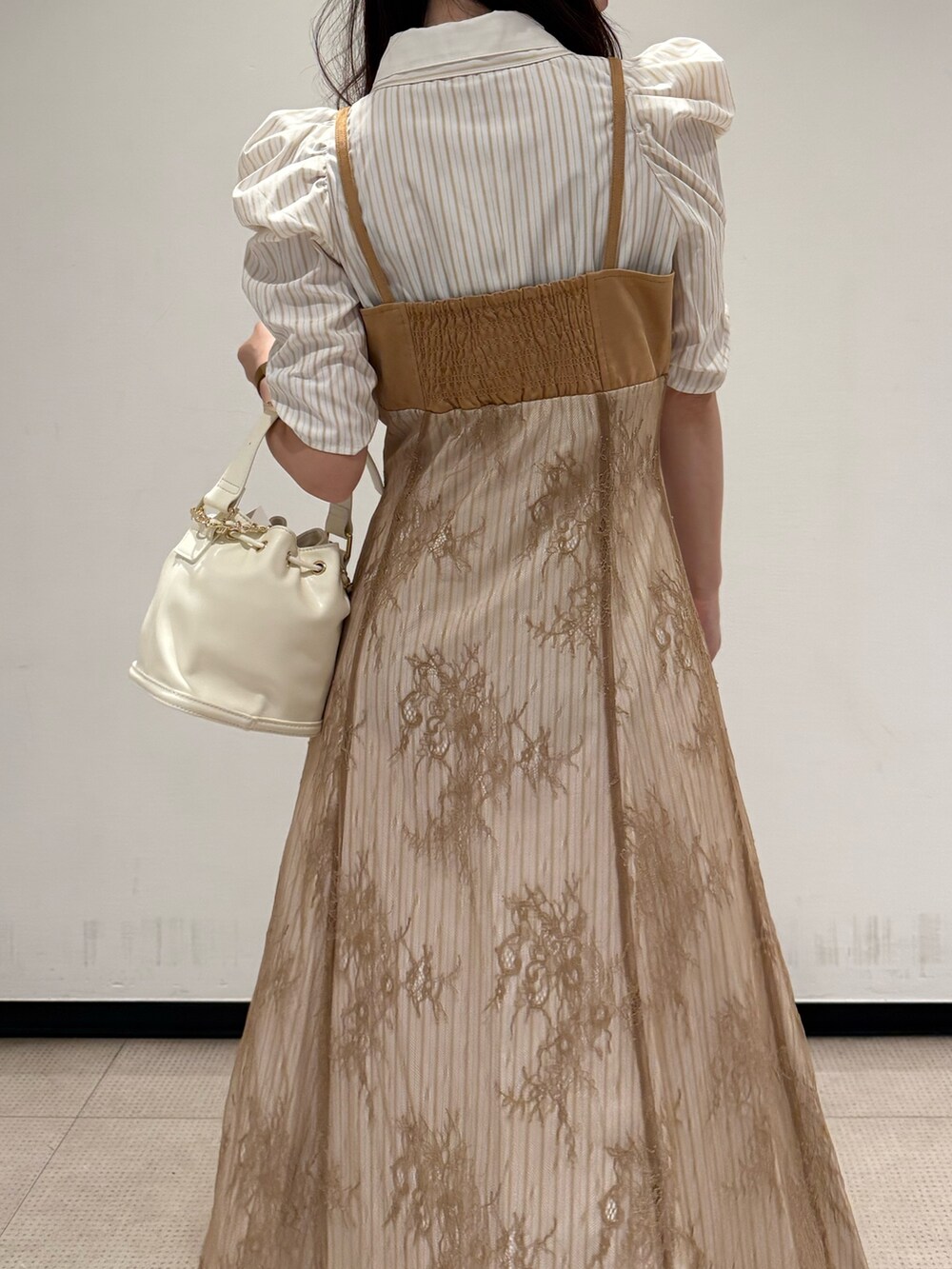ベージュ系のワンピース、ホワイト系のハンドバッグ、ホワイト系のブーツを着用したレディースの夏コーディネートの6枚目の写真