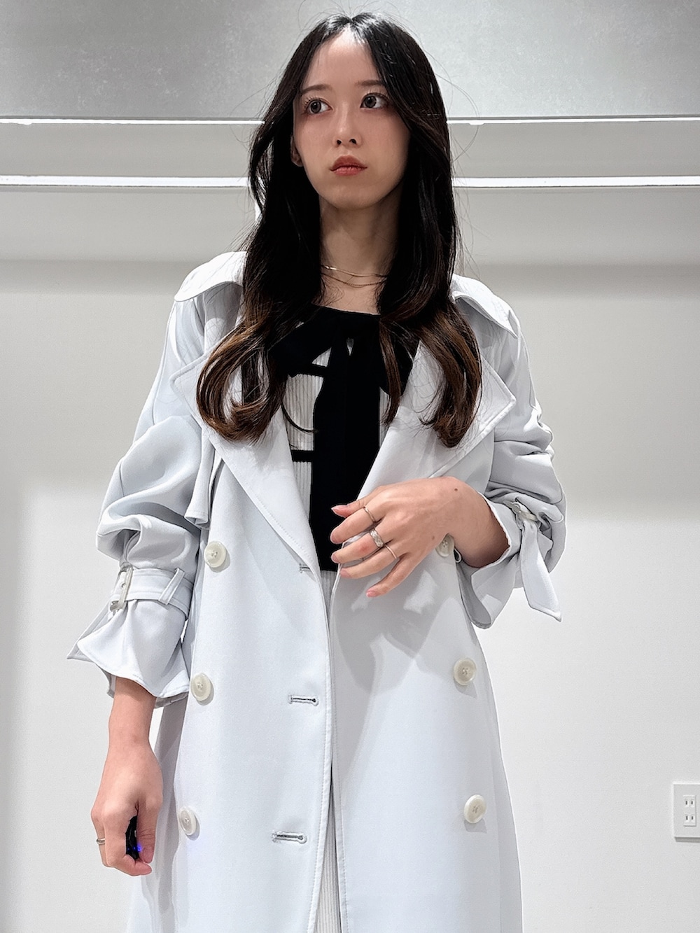 ブルー系のトレンチコート、ホワイト系のブーツ、ホワイト系のワンピースを着用したレディースの冬コーディネートの5枚目の写真