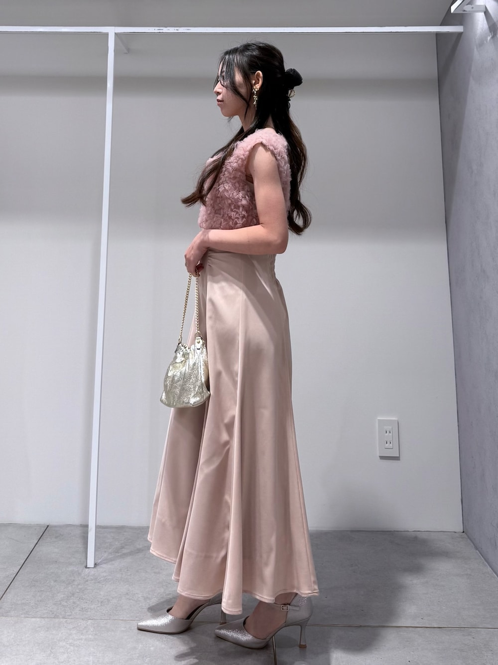 ホワイト系のトレンチコート、ピンク系のドレス、ゴールド系のショルダーバッグを着用したレディースの冬コーディネートの8枚目の写真