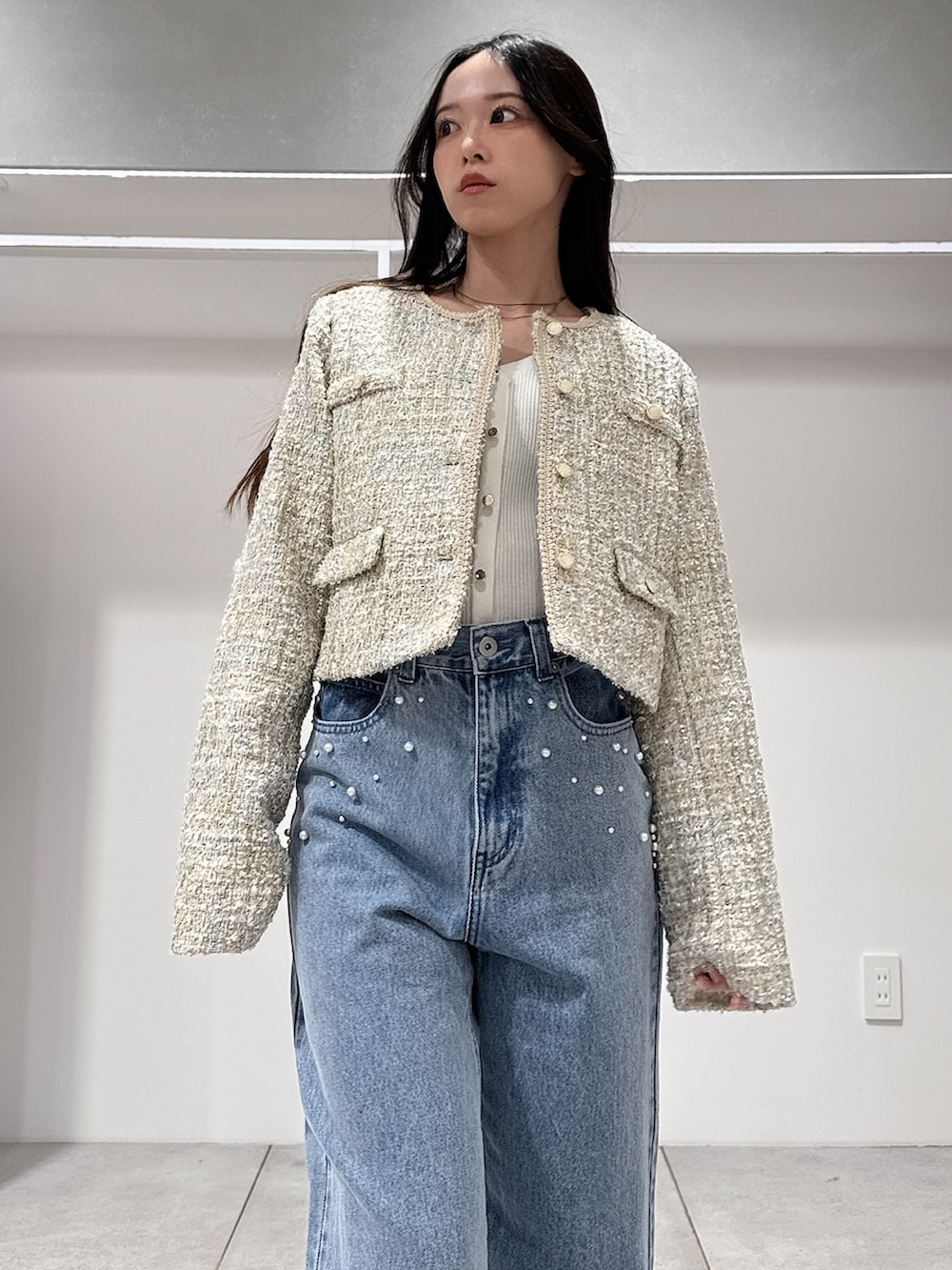 グリーン系のテーラードジャケット、ホワイト系のニット/セーター、ブルー系のデニムパンツを着用したレディースの春コーディネートの4枚目の写真