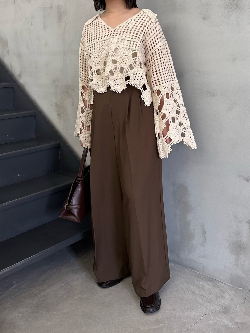 ホワイト系のニット/セーター、ホワイト系のキャミソール、ブラウン系のスラックスを着用したレディースの冬コーディネートの3枚目の写真