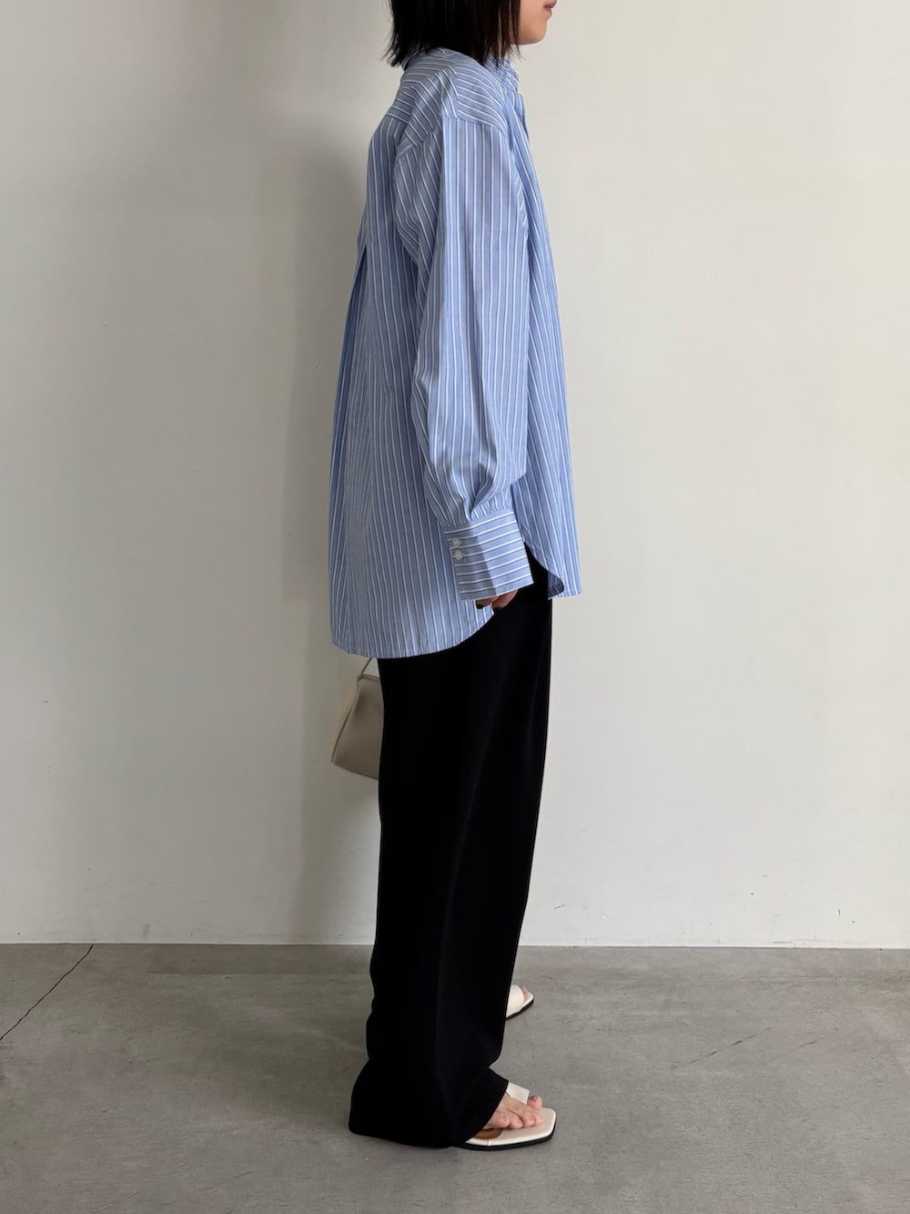 ブルー系のシャツ/ブラウス、ブラック系のその他パンツ、ホワイト系のサンダルを着用したレディースの冬コーディネートの2枚目の写真