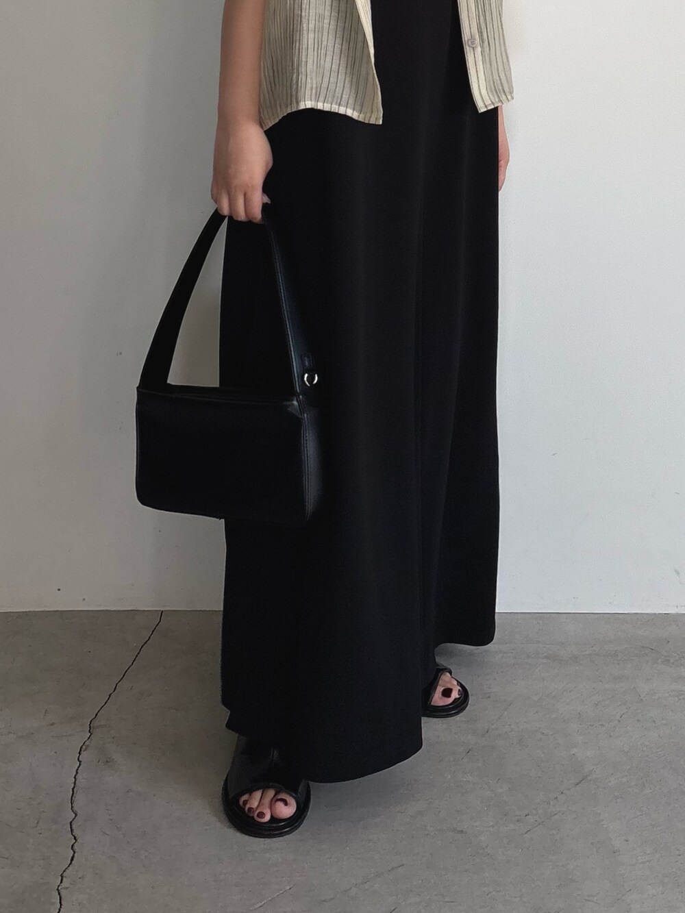 ブラック系のワンピース、ブラック系のショルダーバッグ、ブラック系のサンダルを着用したレディースの夏コーディネートの6枚目の写真