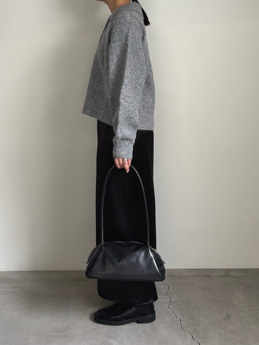 グレー系のカーディガン/ボレロ、ブラック系のスカート、ブラック系のボストンバッグを着用したレディースの秋コーディネートの4枚目の写真