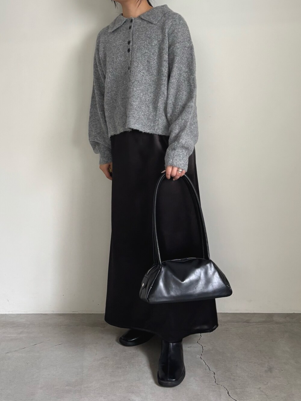 グレー系のカーディガン/ボレロ、ブラック系のスカート、ブラック系のボストンバッグを着用したレディースの秋コーディネートの3枚目の写真