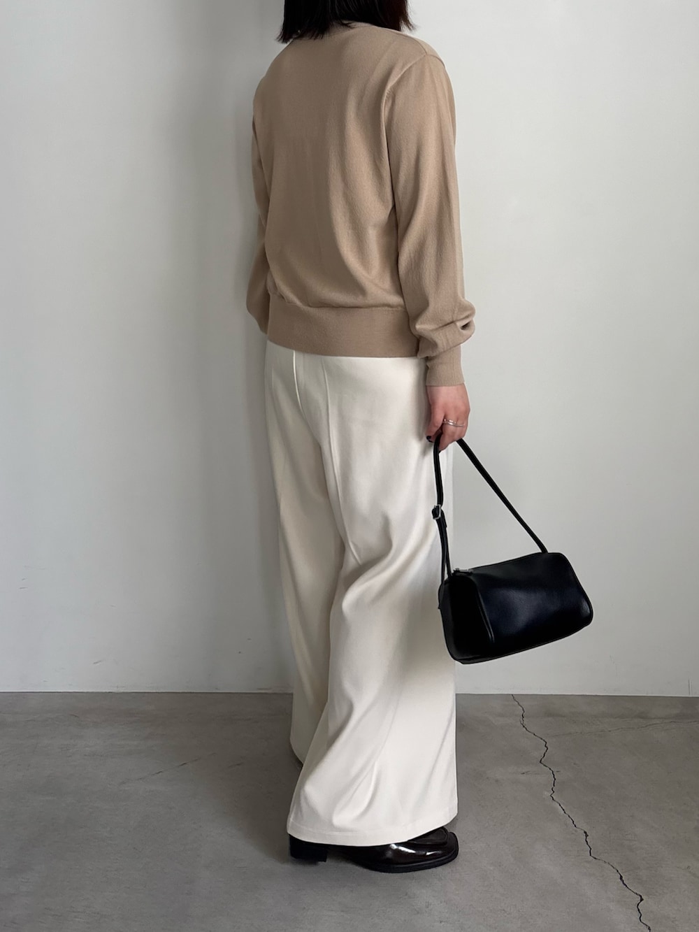 ベージュ系のカーディガン/ボレロ、ホワイト系のキャミソール、ホワイト系のスラックスを着用したレディースの冬コーディネートの3枚目の写真