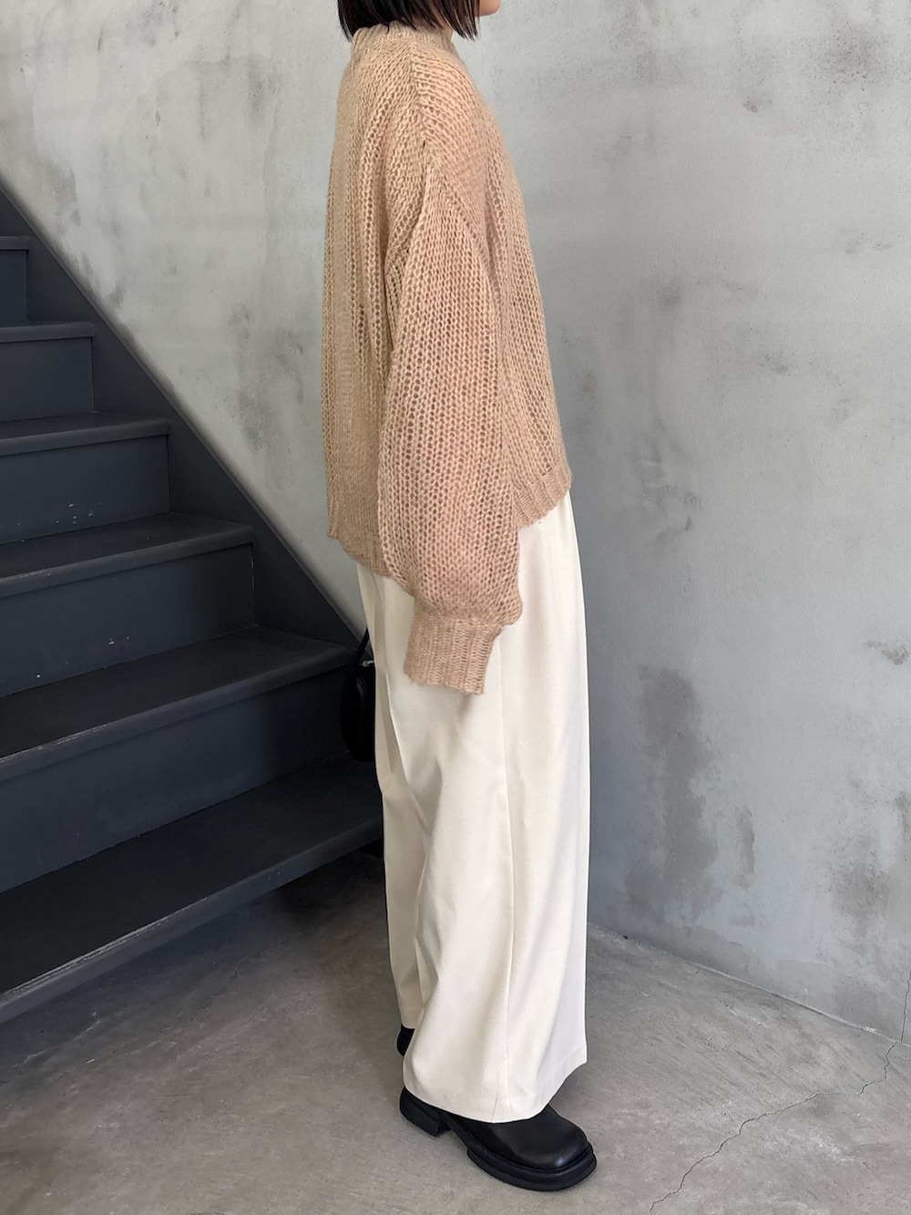 ベージュ系のニット/セーター、ホワイト系のキャミソール、ブラック系のスリッポンを着用したレディースの冬コーディネートの2枚目の写真