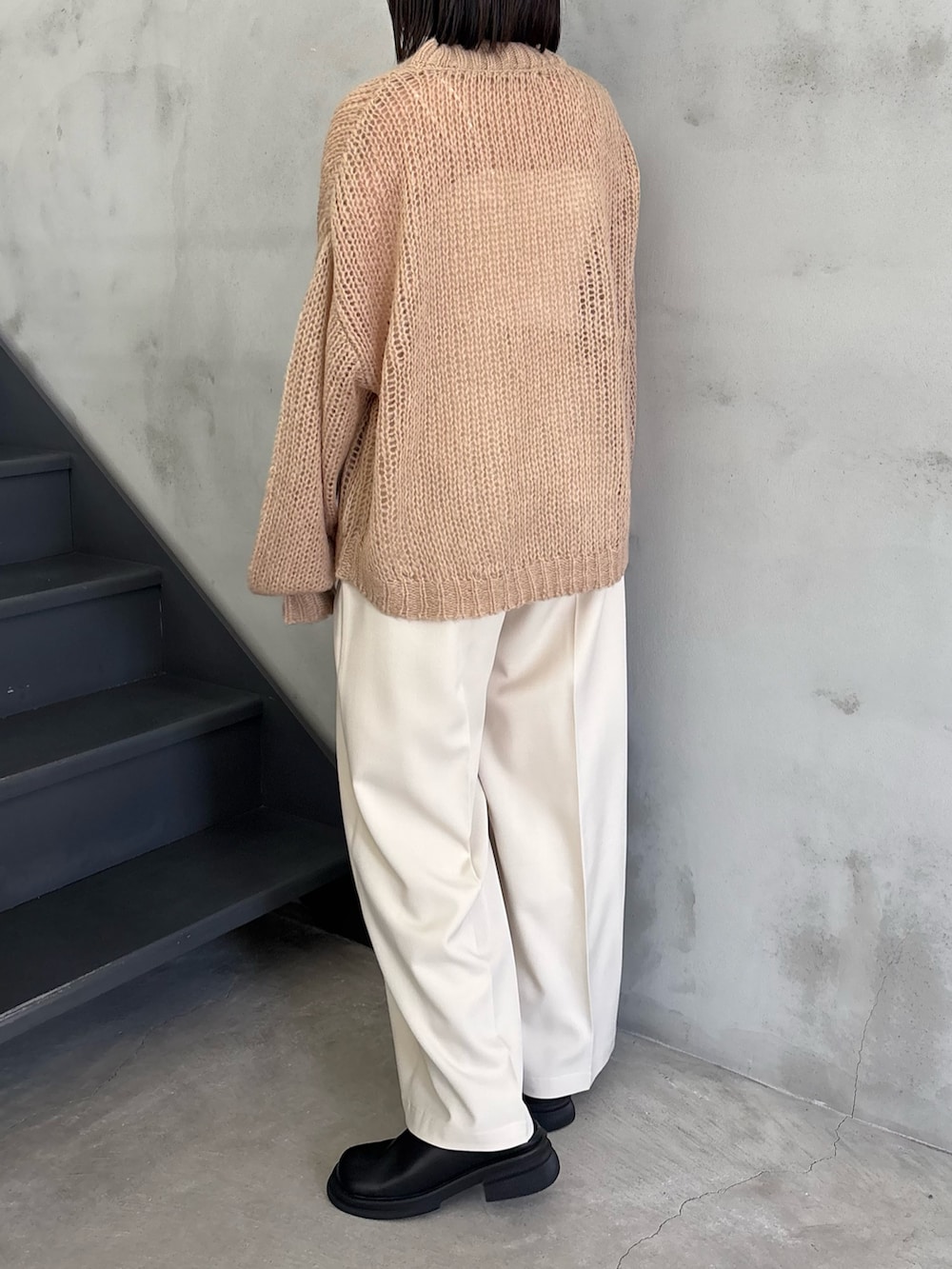 ベージュ系のニット/セーター、ホワイト系のキャミソール、ブラック系のスリッポンを着用したレディースの冬コーディネートの3枚目の写真