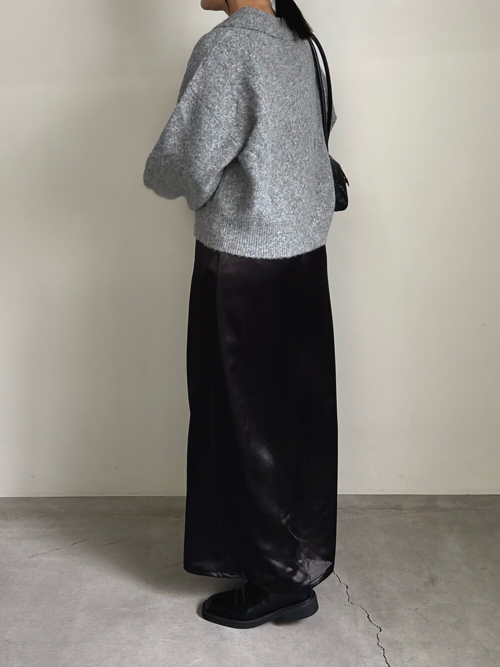 グレー系のカーディガン/ボレロ、ブラック系のスカート、ブラック系のボストンバッグを着用したレディースの秋コーディネートの2枚目の写真