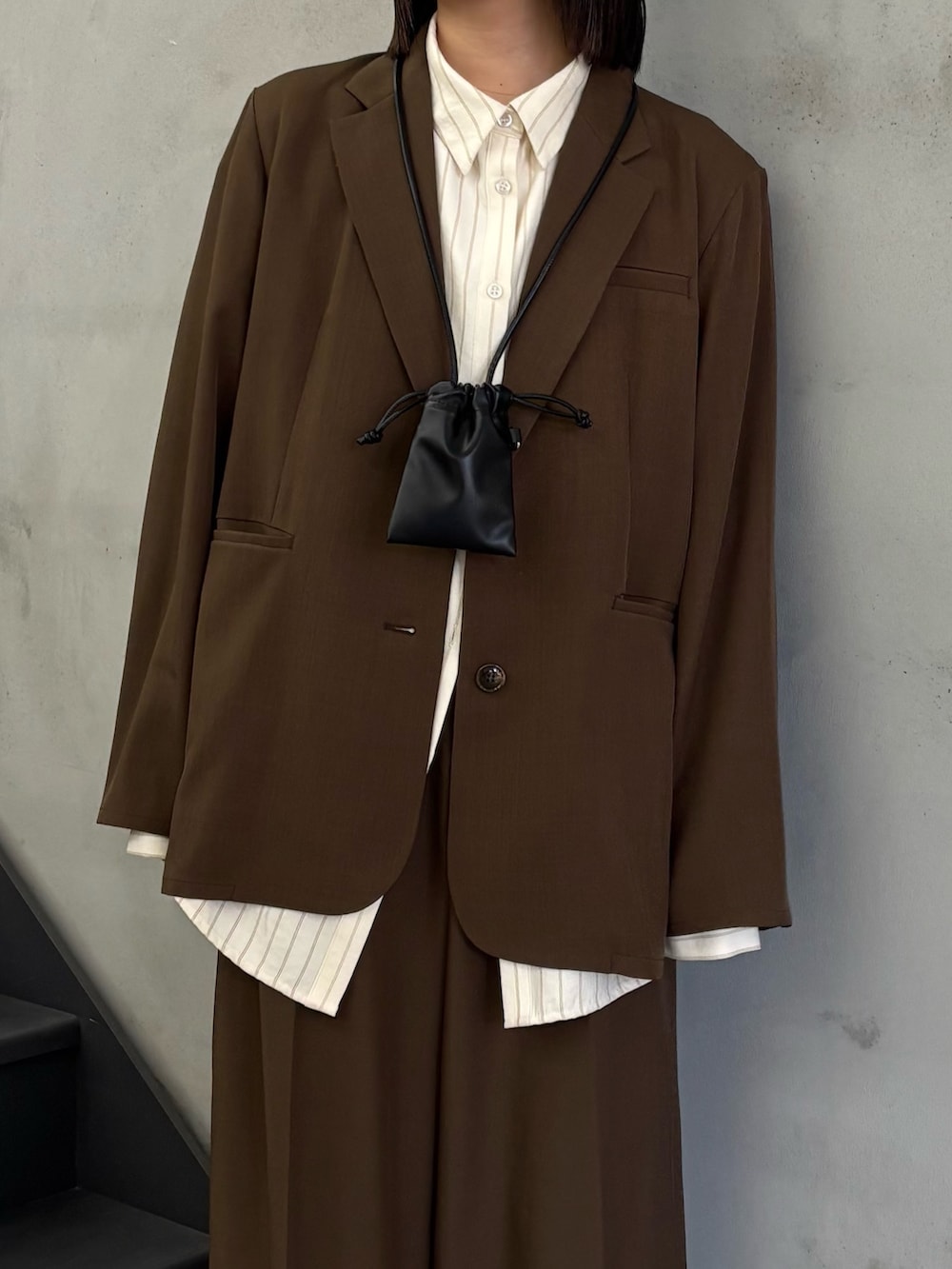 ホワイト系のシャツ/ブラウス、ブラウン系のテーラードジャケット、ブラウン系のスラックスを着用したレディースの冬コーディネートの6枚目の写真