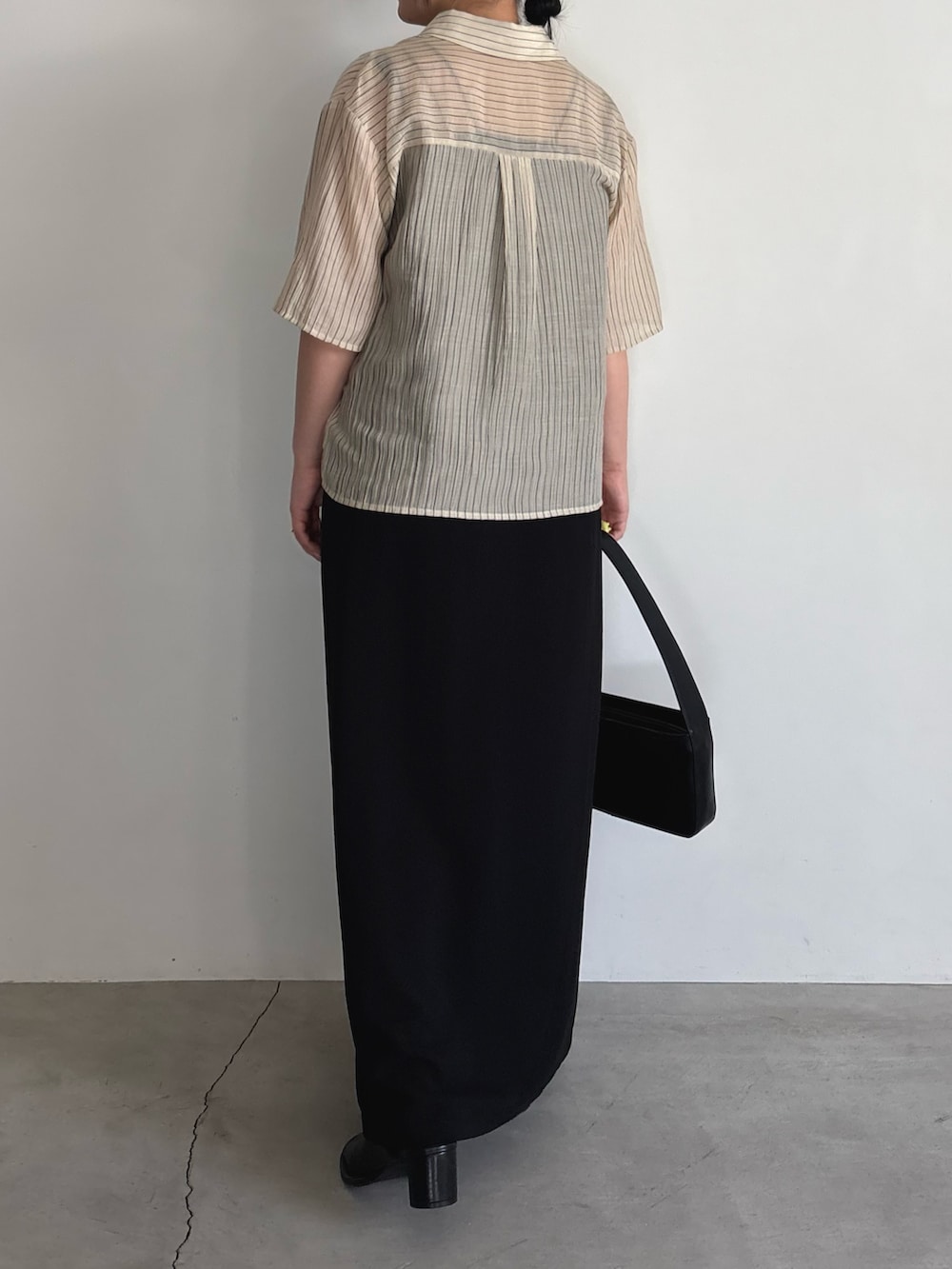 ブラック系のワンピース、ブラック系のショルダーバッグ、ブラック系のサンダルを着用したレディースの夏コーディネートの3枚目の写真