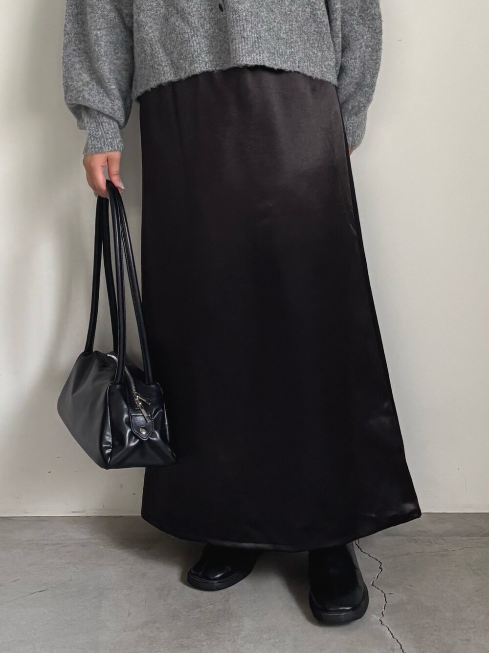 グレー系のカーディガン/ボレロ、ブラック系のスカート、ブラック系のボストンバッグを着用したレディースの秋コーディネートの5枚目の写真