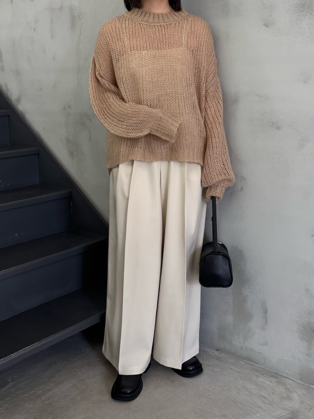 ベージュ系のニット/セーター、ホワイト系のキャミソール、ブラック系のスリッポンを着用したレディースの冬コーディネートの4枚目の写真