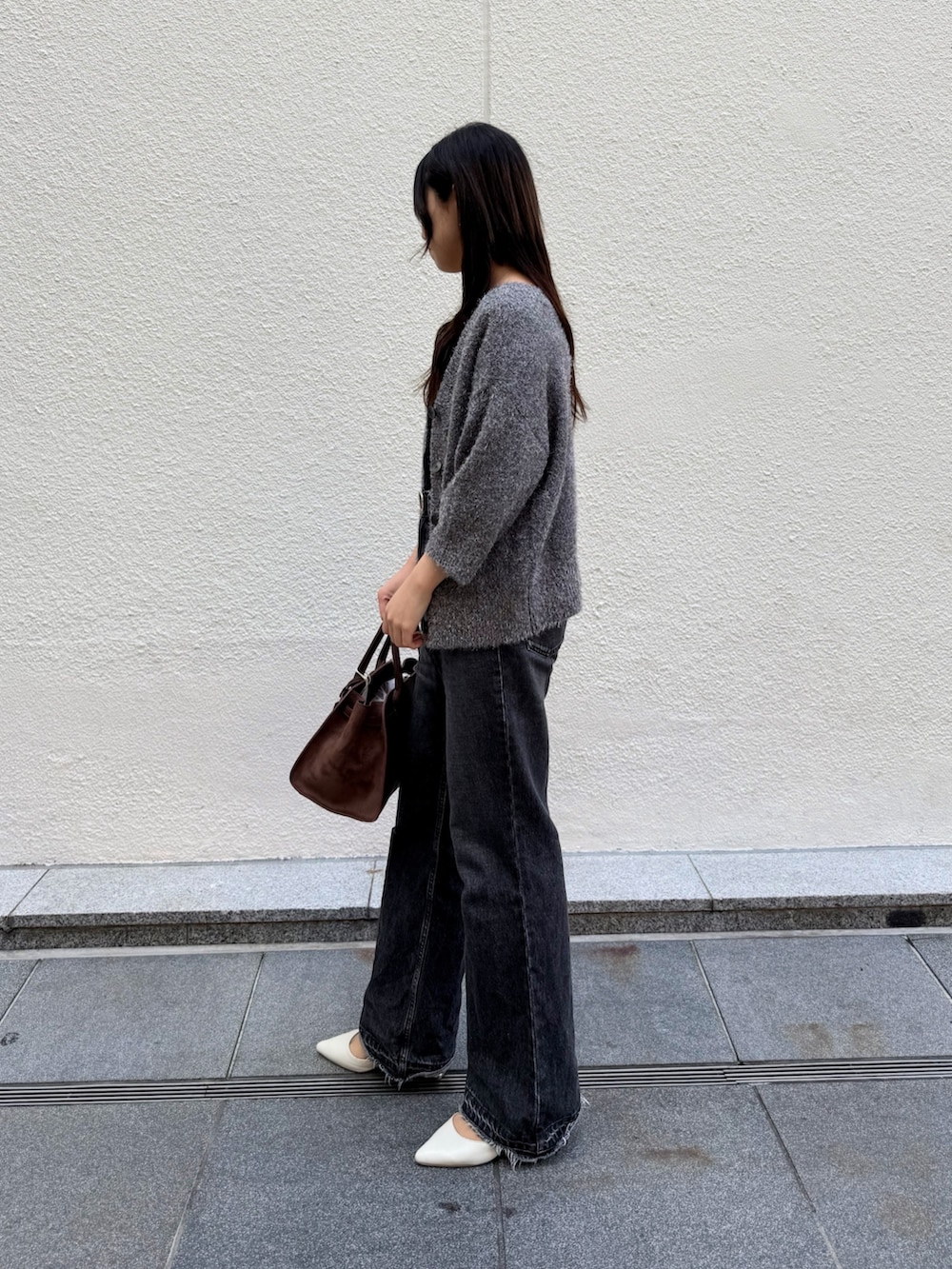 ブラウン系のトートバッグ、ブラック系のタンクトップ、グレー系のカーディガン/ボレロを着用したレディースの秋コーディネートの5枚目の写真
