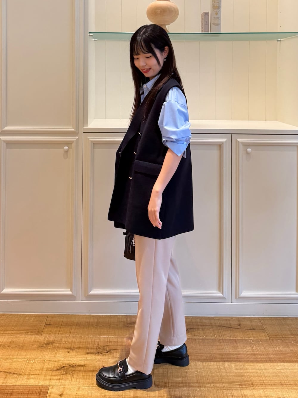 ブルー系のシャツ/ブラウス、ブルー系のベスト、ベージュ系のその他パンツを着用したレディースの秋コーディネートの3枚目の写真