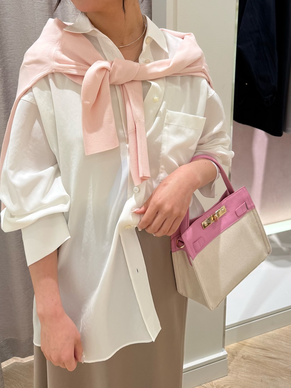 ピンク系のショルダーバッグ、ピンク系のカーディガン/ボレロ、ホワイト系のシャツ/ブラウスを着用したレディースの春コーディネートの6枚目の写真